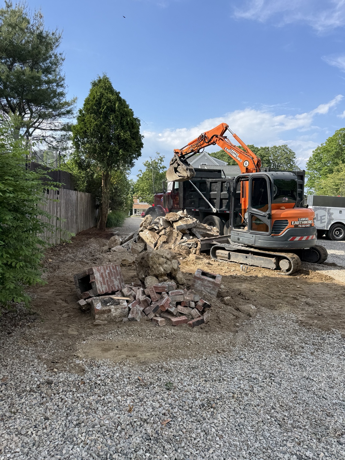 Excavator loading broken concrete and masonry into a dump truck