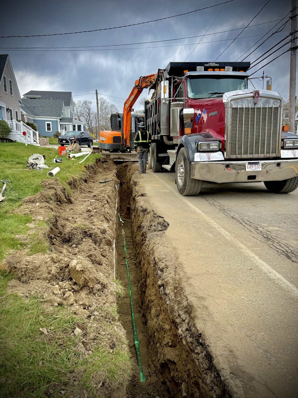 Roadside utility trench with excavator and dump truck